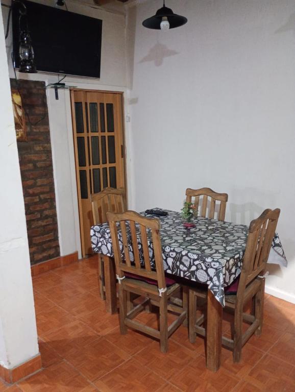 una sala da pranzo con tavolo, sedie e televisione di Casa Cómoda en Barreal a Barreal