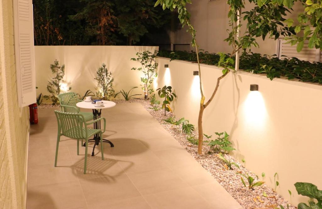 a patio with a table and chairs and plants at FaliroRelax F2 in Athens
