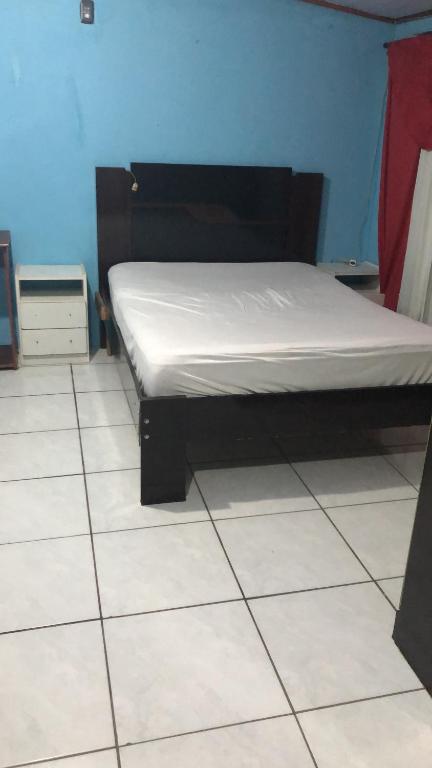 ein Bett auf einem gefliesten Boden in einem Zimmer in der Unterkunft Kit Net in Torres