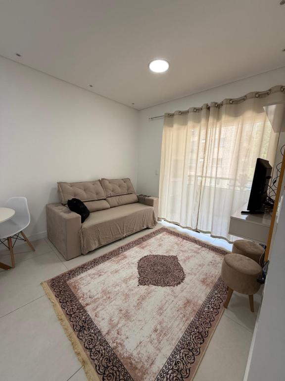 een woonkamer met een bank en een tapijt bij Apartamento Elegante 2 Quartos in Balneário Camboriú