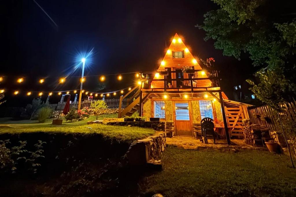 a large wooden house with lights on it at night at Villa Alpi in Nižepole