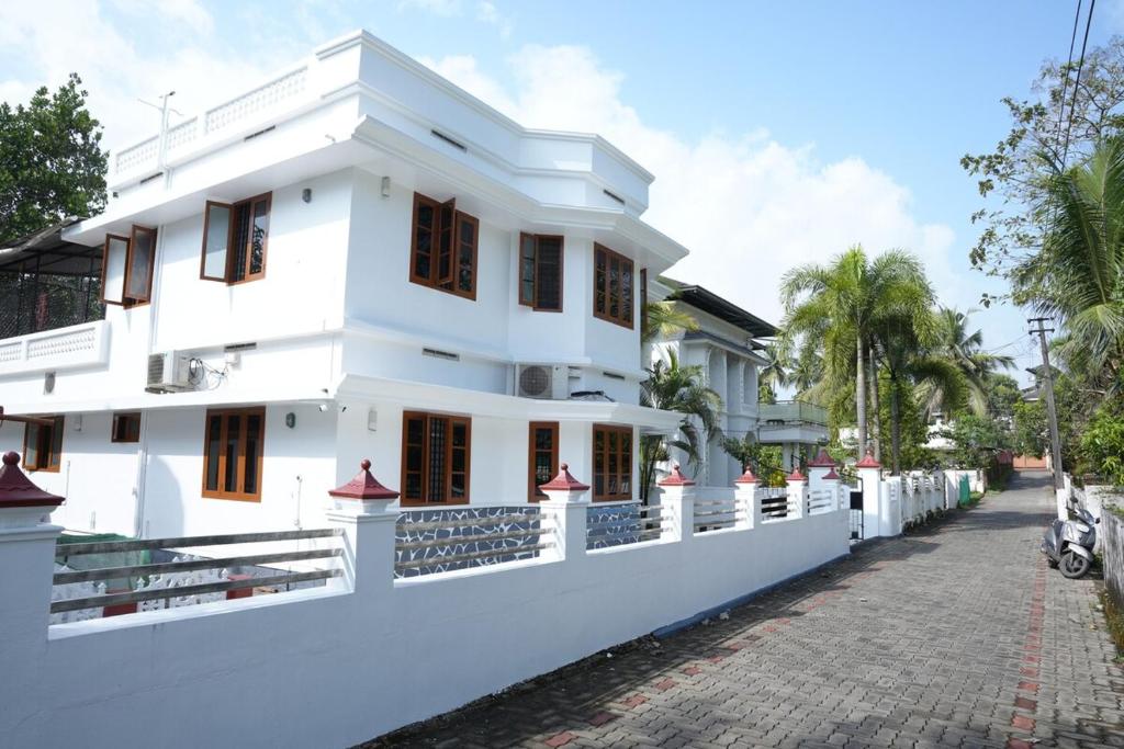 a white house with a street in front of it at White Haven in Angamaly