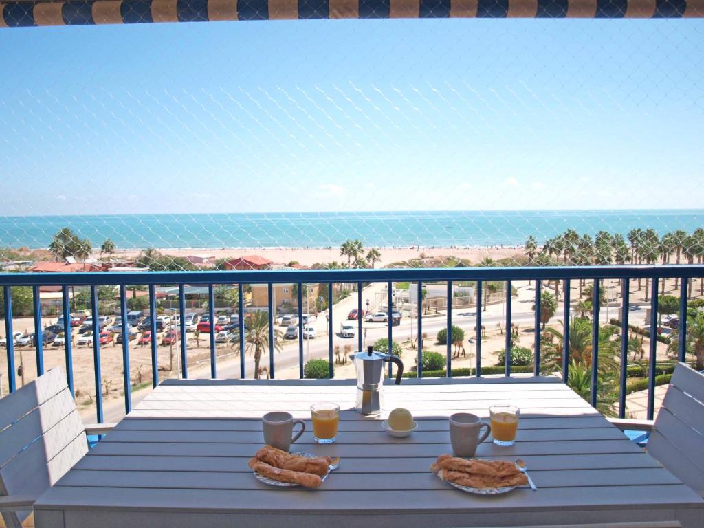 una mesa en un balcón con vistas a la playa en ApartUP Patacona Panoramic, en Valencia