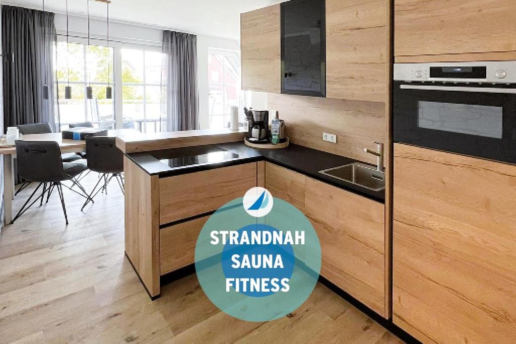 于斯德Winkelschiffchen III mit Sauna的厨房里有水槽和炉灶。 上层烤箱