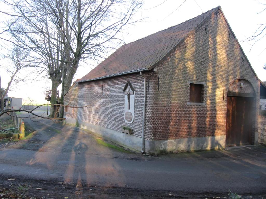 un viejo edificio de ladrillo con una puerta en una calle en B&B Bodegem en Dilbeek