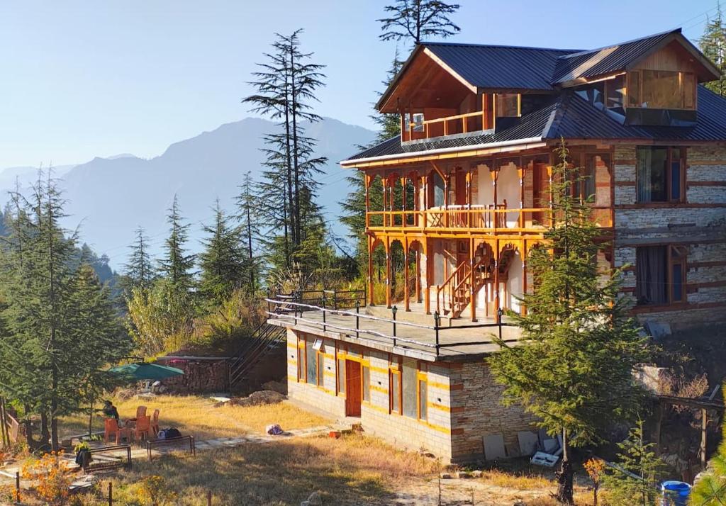 a house with a balcony on the side of it at Himalayan Baseraa in Sainj