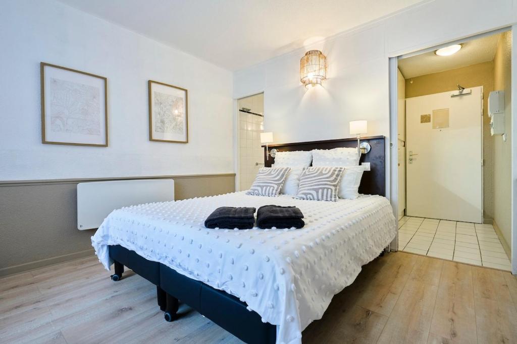 een slaapkamer met een groot bed met twee handdoeken erop bij Studio Vauban, Lille in Lille