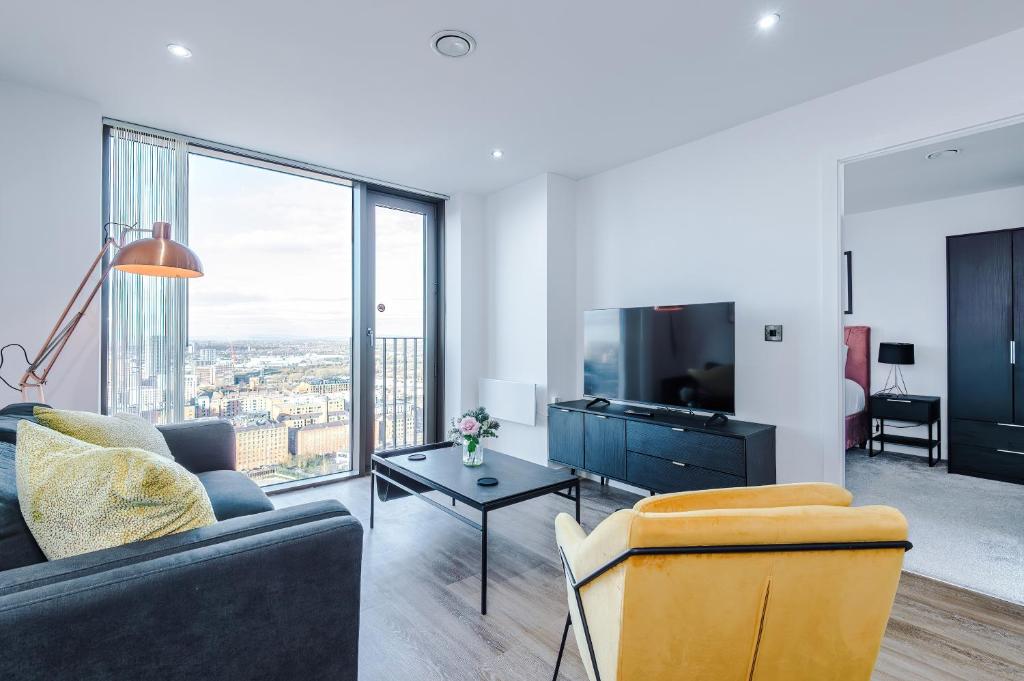 een woonkamer met een bank en een tv bij City View Apartment with Pool in Manchester