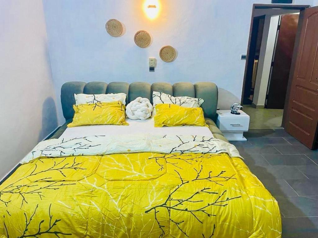 ParakouRésidences Fifamè的一间卧室配有一张黄色棉被的床