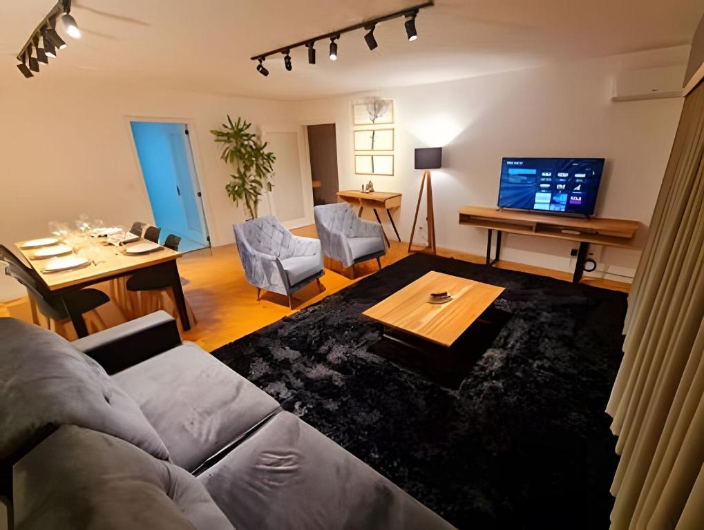 a living room with a couch and a table at Apartamento Major Nicoletti in Gramado