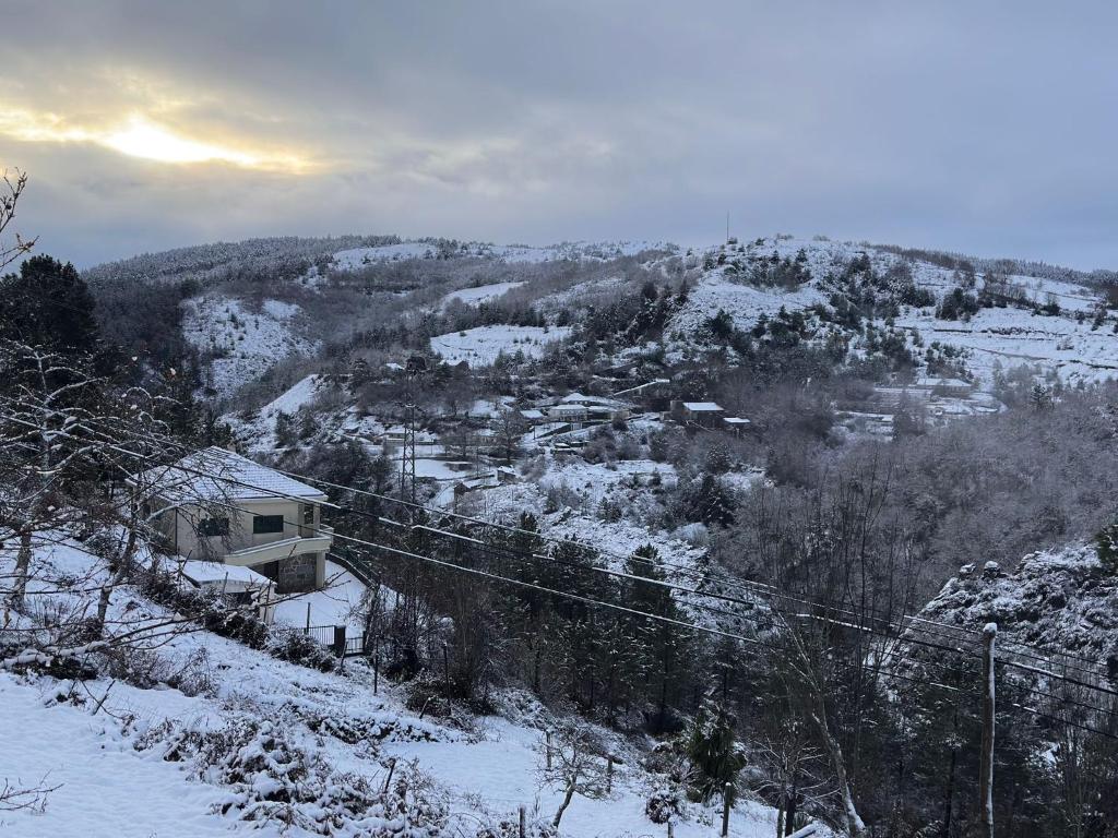 een uitzicht op een met sneeuw bedekte berg met een stad bij O cantinho do Avô Alberto 