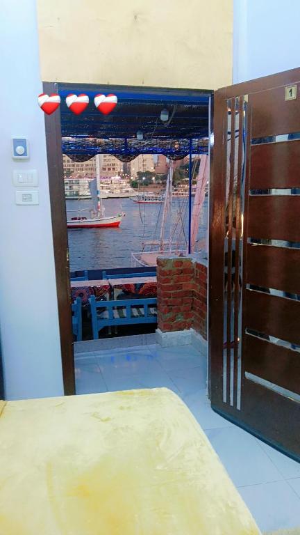 a door with a window with a view of a harbor at Onaty Narty Guest house Nile view in Aswan