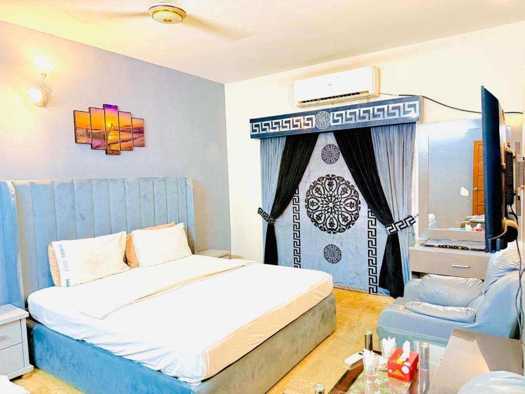 a bedroom with a bed and a television in it at Karachi Family Guest House in Karachi