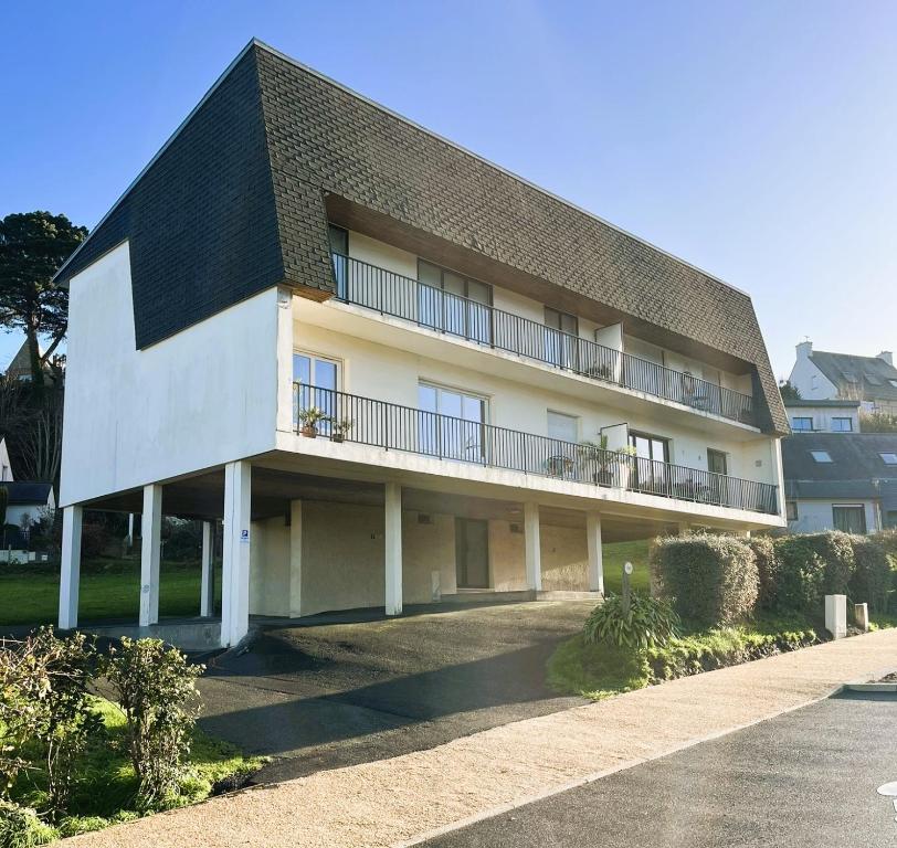 a large white building with a black roof at Traezh ar vag - Appartement Plage Perros-Guirec in Perros-Guirec