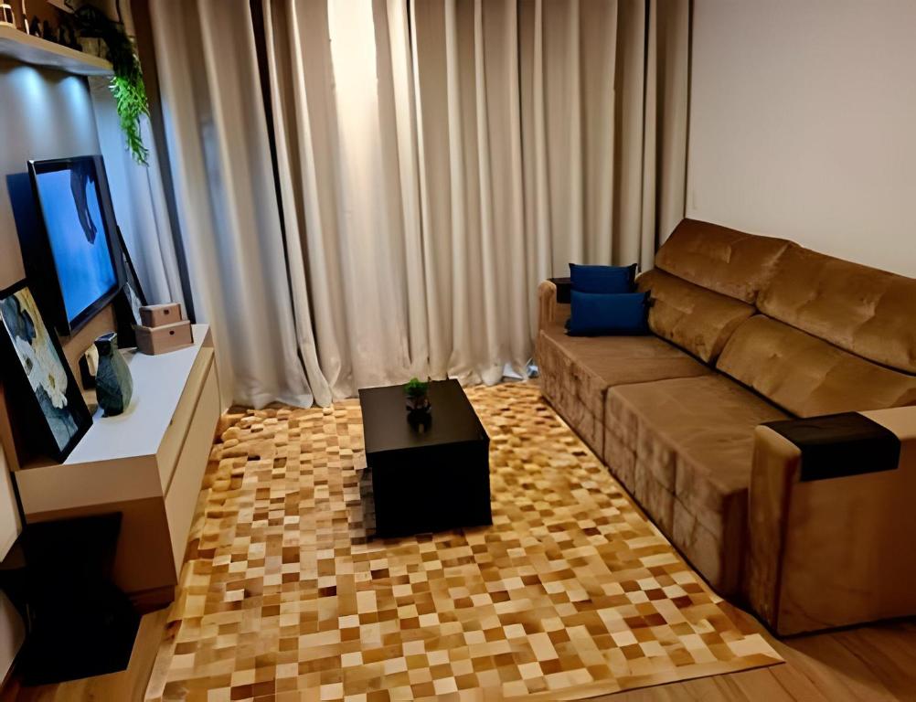 a living room with a couch and a television at Gramado Loft 105 in Gramado