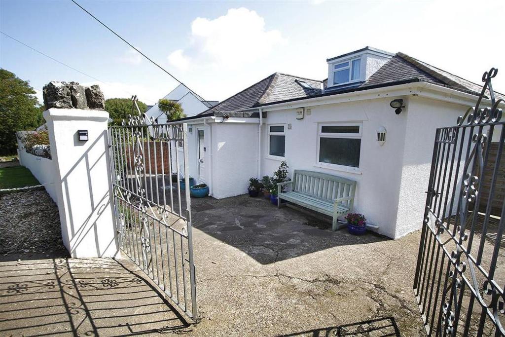 a white house with a gate and a bench at 3 Bed in Overton oc-hh2103 in Port-Eynon