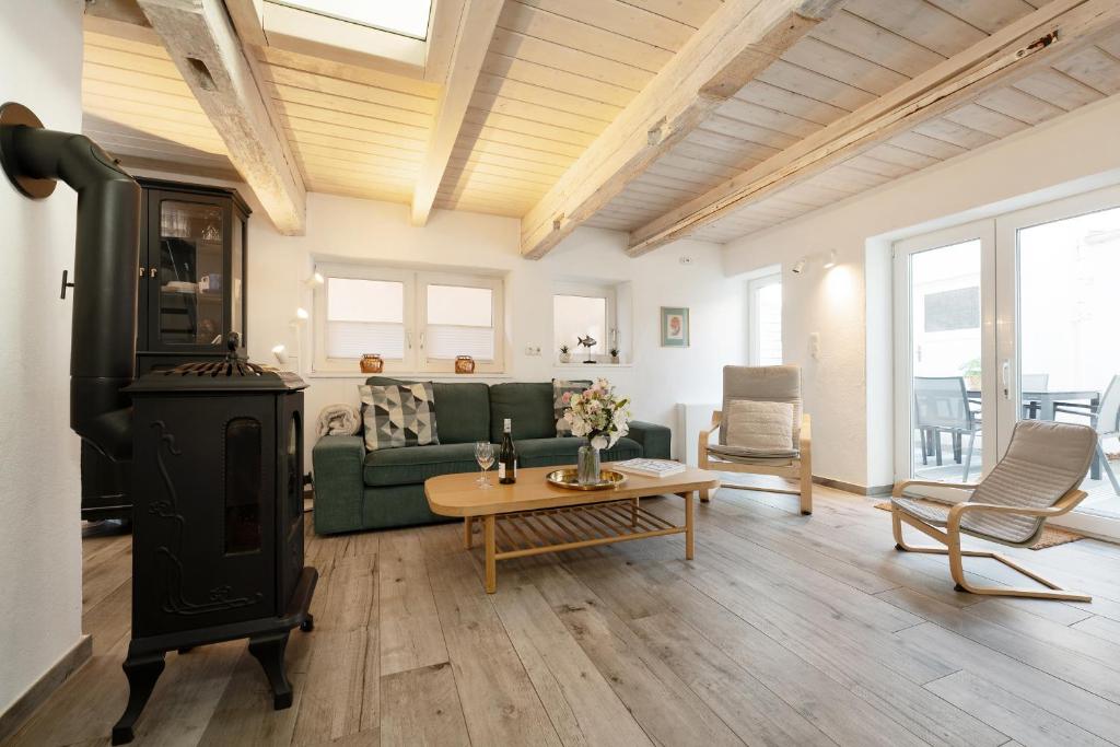 a living room with a green couch and a wood stove at Haus 1805 Fehmarn in Fehmarn