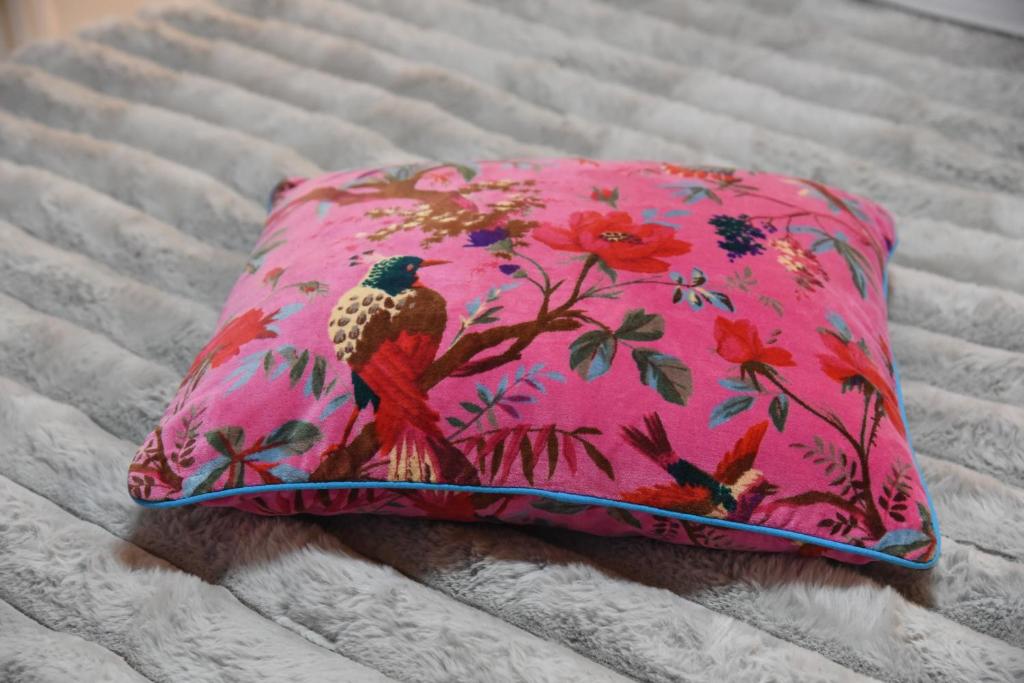 een roze kussen met een vogel erop op een bed bij Ioni Home in Tsagarada