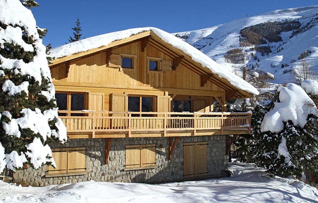 une cabane en rondins dans la neige dans l'établissement Odalys Chalet La Muzelle, à Les Deux Alpes