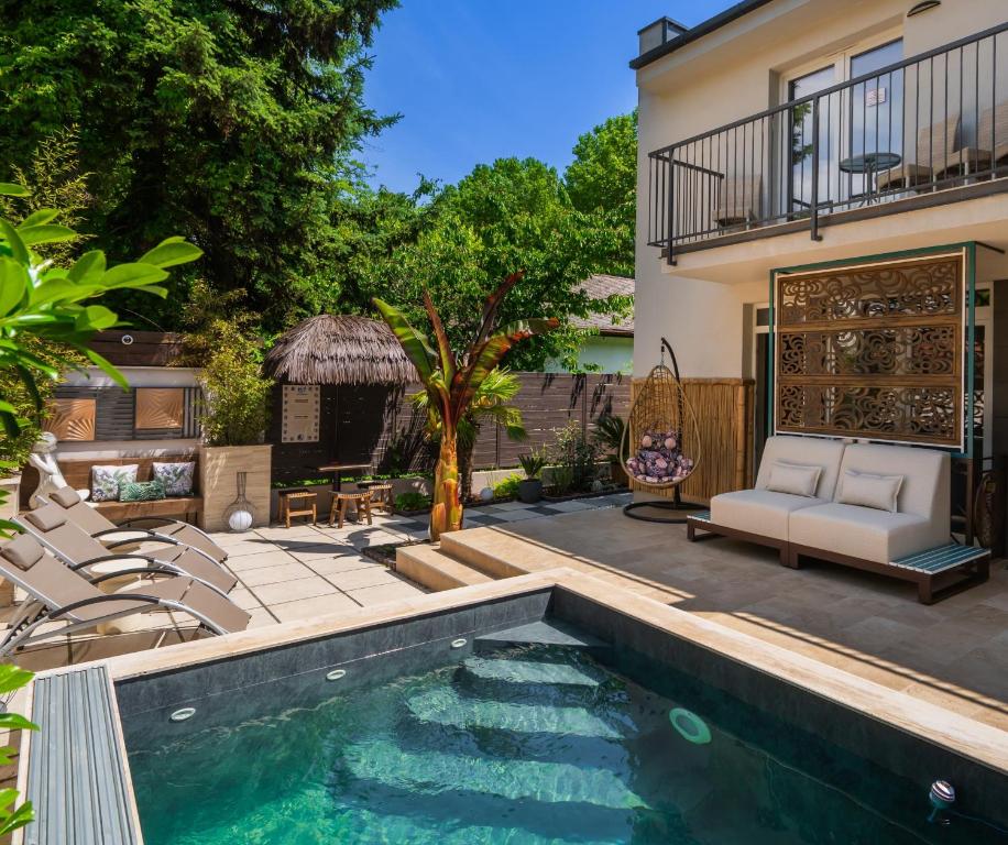 a backyard with a swimming pool and chairs and a house at Aragda 1 in Siófok