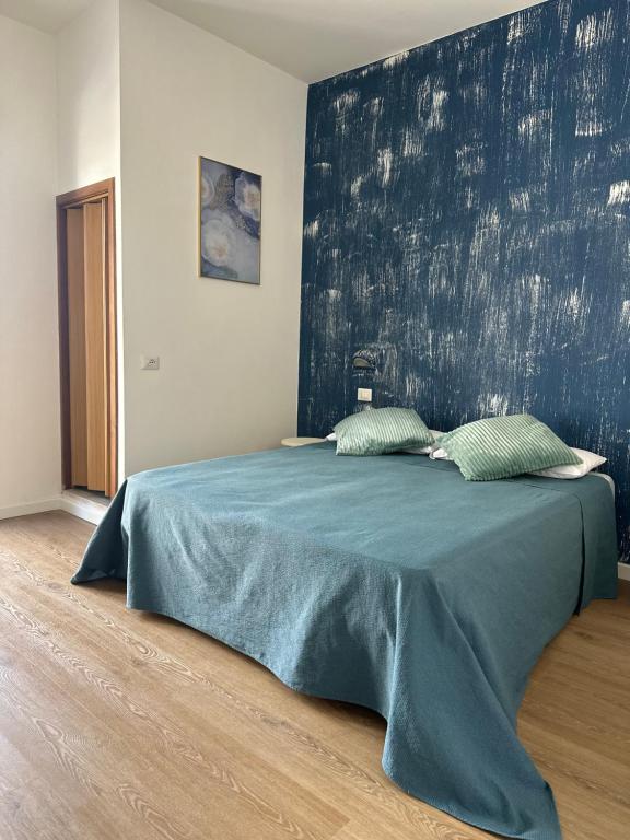 een slaapkamer met een groot bed met een blauwe deken bij Hotel Sylva in Cattolica