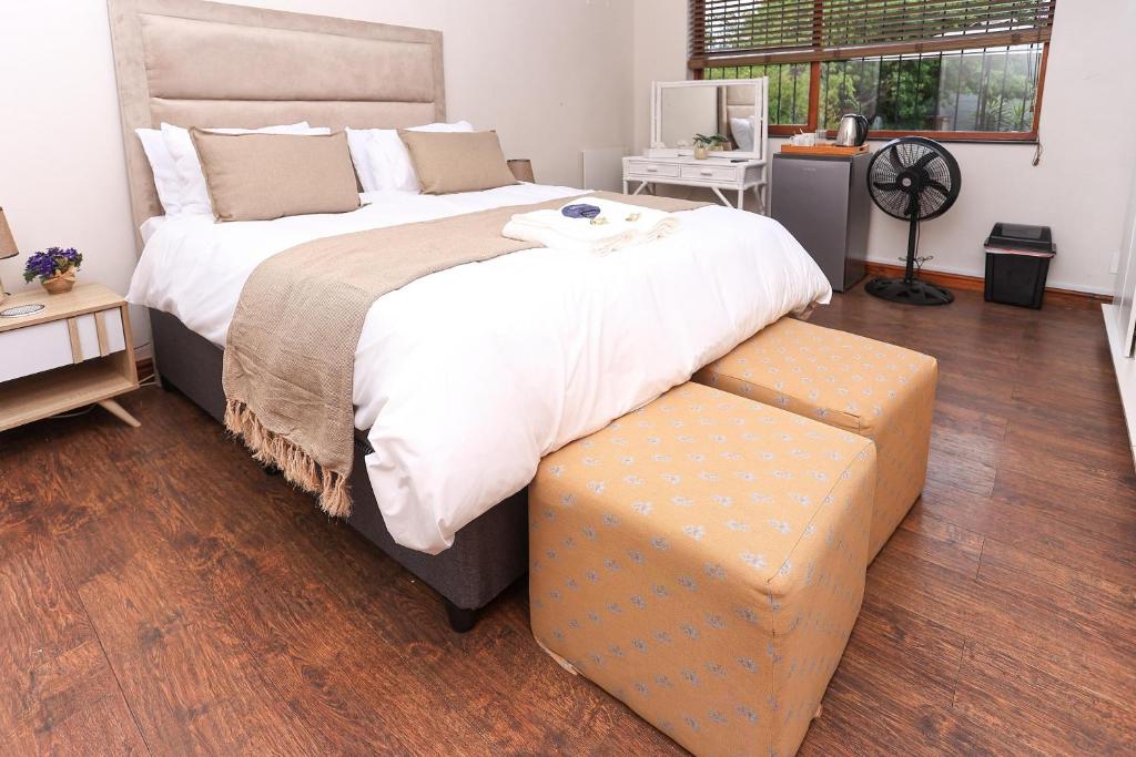 a large bedroom with a large bed with a ottoman at African Oasis Morrocco in Somerset West