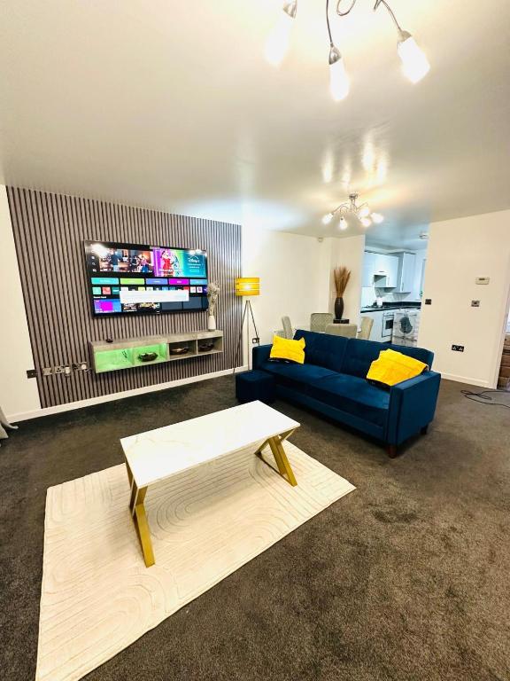 een woonkamer met een blauwe bank en een tv bij The Pheasant - Luxury 3-bedroom Apartment in Dartford in Dartford