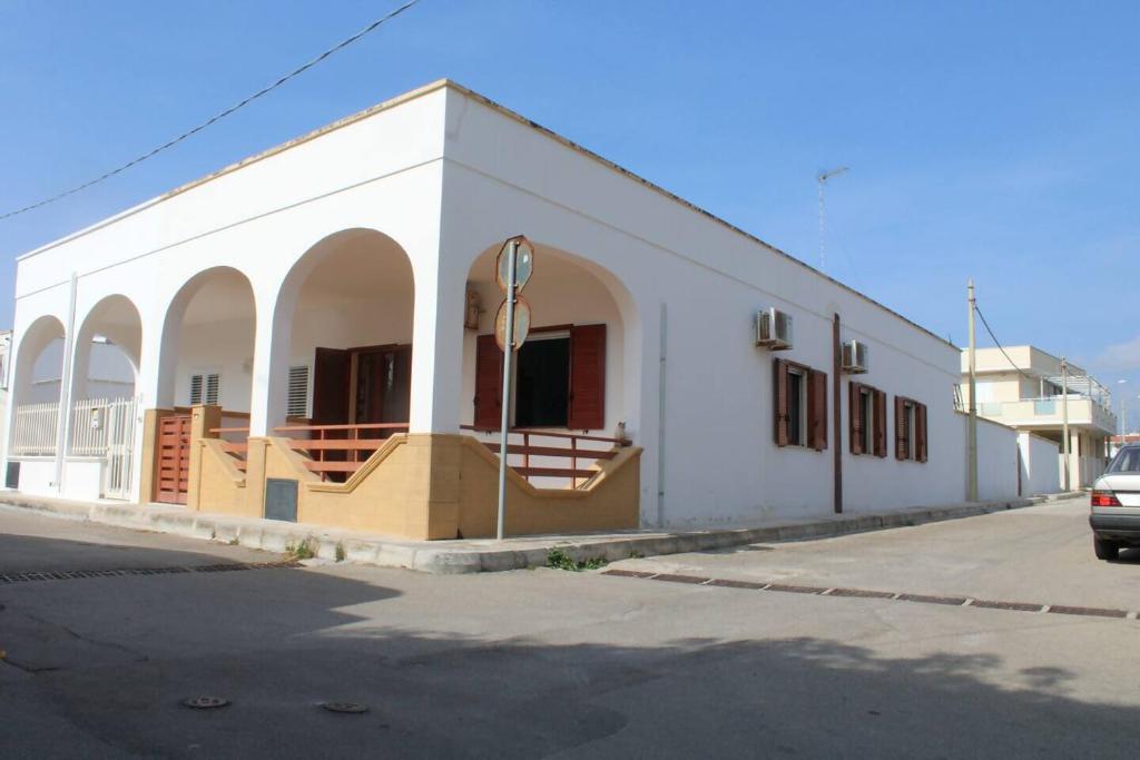 een wit gebouw met bogen aan de zijkant bij Villetta AmaMare in Torre Lapillo