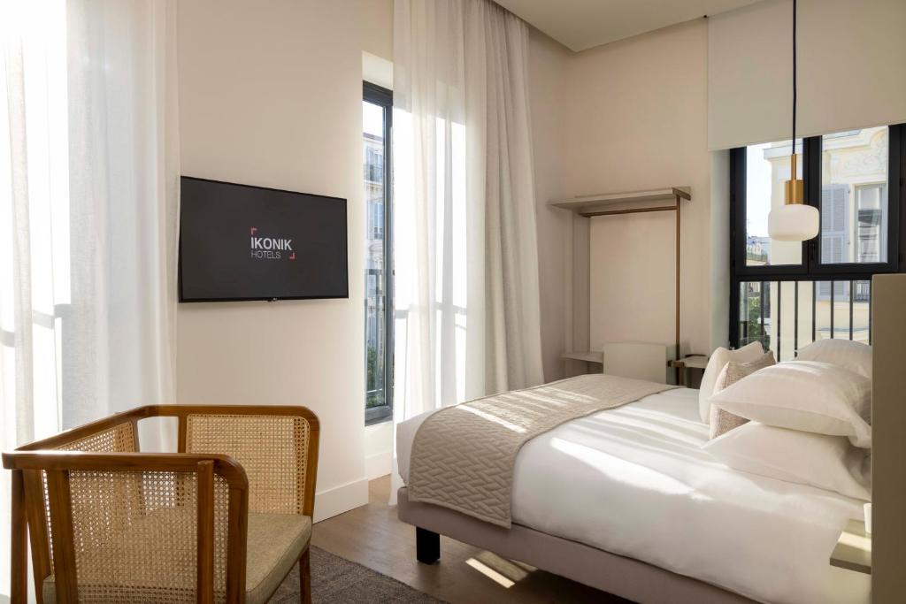 een slaapkamer met een bed en een tv aan de muur bij Ikonik Jean Médecin in Nice
