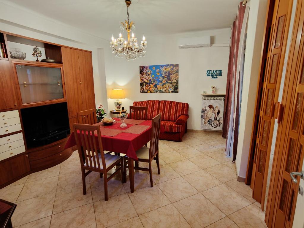 una sala da pranzo con tavolo, sedie e divano di Atlantis Apartment Trieste a Trieste