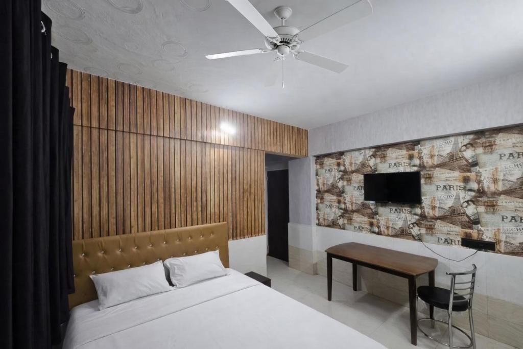 a bedroom with a bed and a table and a tv at Luxurious Private Room in thane only for Male in Thane