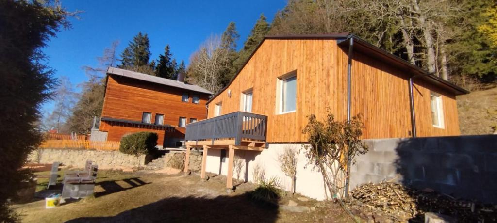 uma grande casa de madeira com uma cerca em frente em Chata POD HOUBOVÝM VRCHEM em Horní Planá