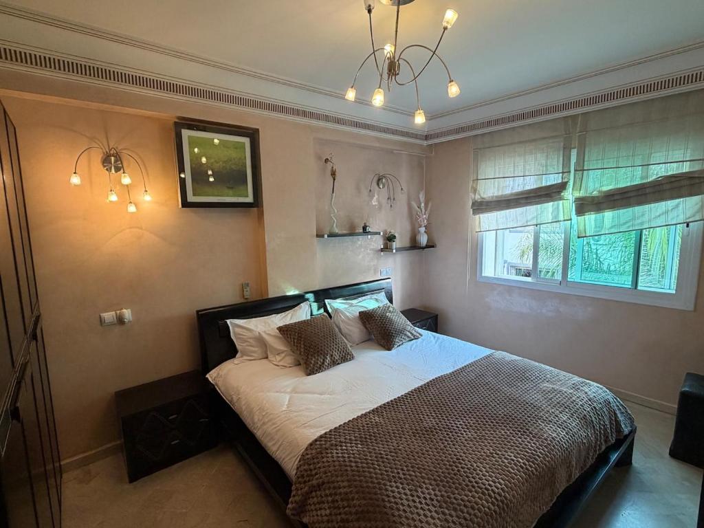 a bedroom with a bed and a window at Grand 3 pièces de standing, confort premium in Casablanca