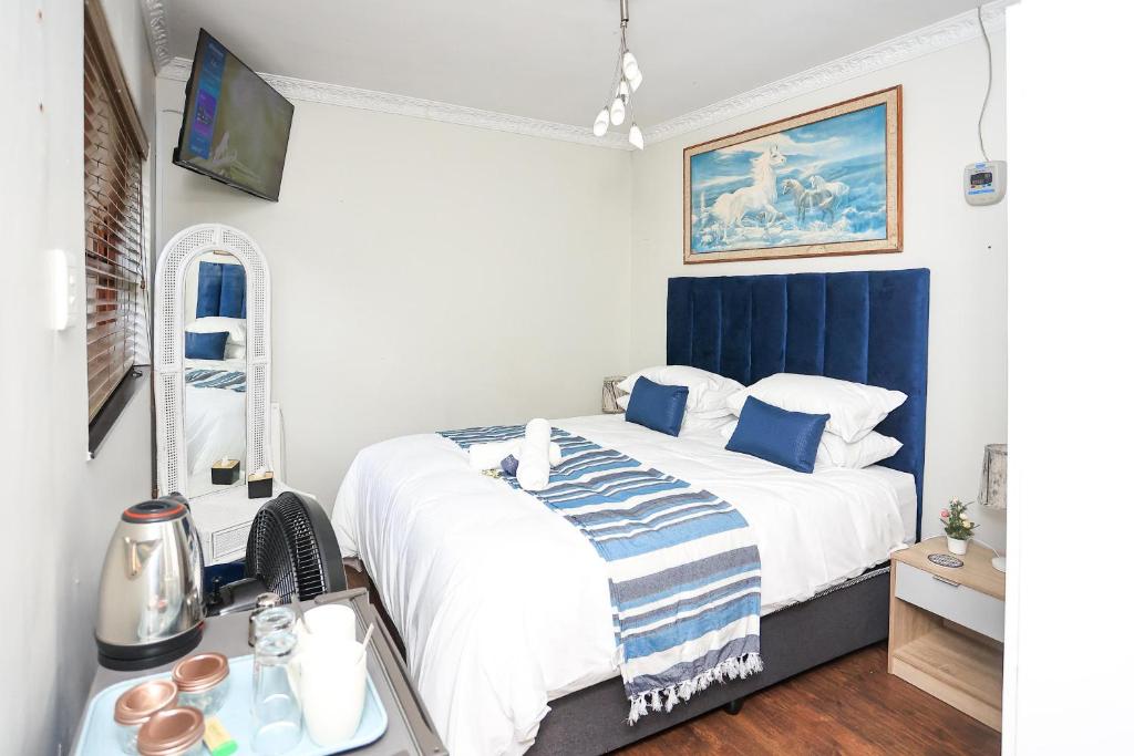 a bedroom with a large bed with a blue headboard at African Oasis Cameroon in Somerset West
