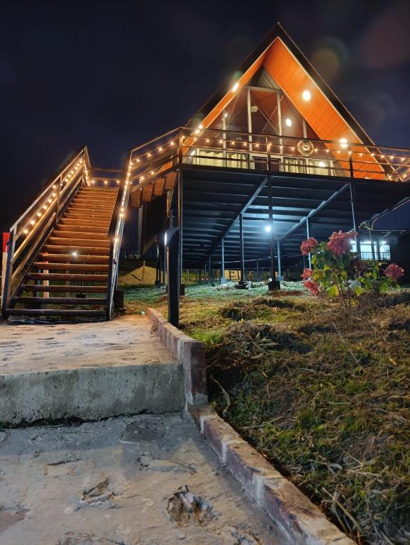 a building with stairs and lights on it at night at Cabaña El Encanto in El Porvenir