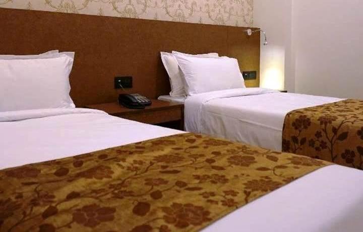 帕罗Penchu Boutique Hotel的有两张床和一部电话的酒店房间