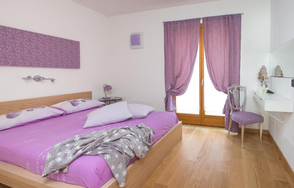um quarto com uma cama roxa com cortinas roxas em Casa Smith e Bice em Bormio
