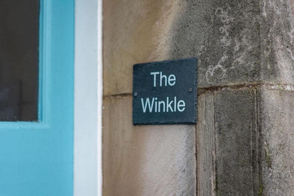 a sign that says the whiskie on the side of a building at The Winkle - Elie in Elie