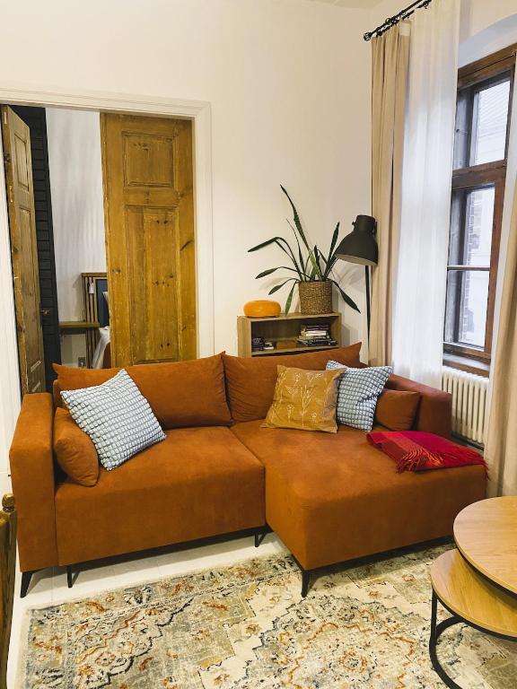 a brown couch with pillows in a living room at SecondHomeViljandi Apartment in Viljandi