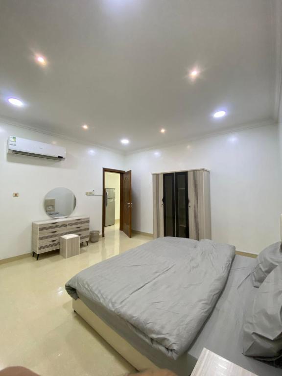 una camera da letto bianca con un letto e uno specchio di شقق vip a Al Hofuf