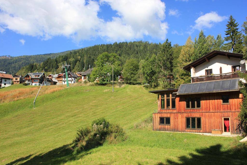 ein Haus auf einem Hügel mit einem Grasfeld in der Unterkunft Haus Sigrid in Bad Kleinkirchheim