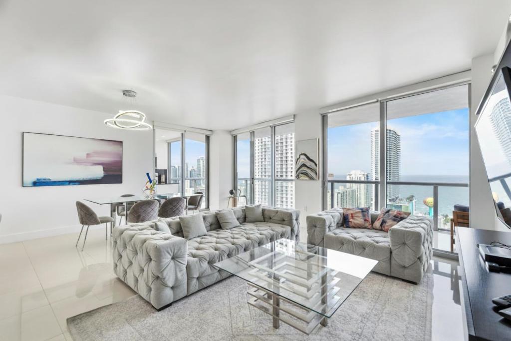 ein Wohnzimmer mit Sofa und Tisch in der Unterkunft Spacious Luxury Apartment at Beachwalk Resort with Ocean Views and Private Foyer in Hallandale Beach