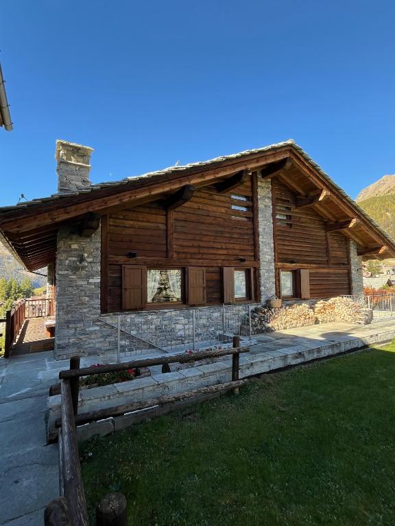 a log cabin with a fence in front of it at L'Atelier du Temps - Chalet Pompon in Cogne