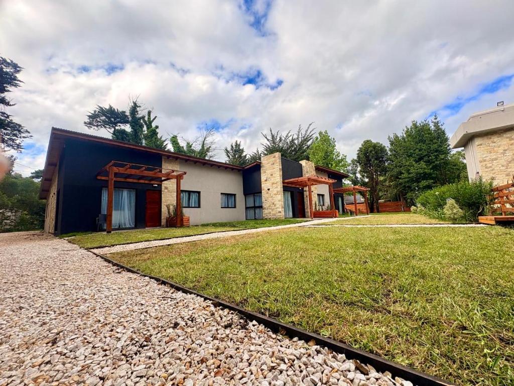 een huis met een grasveld ervoor bij Complejo Malama Kai in Mar de Cobo