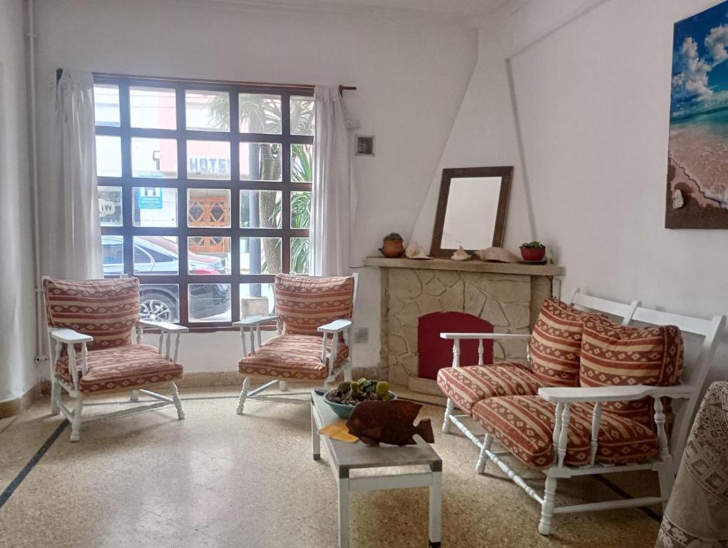 een woonkamer met stoelen en een open haard bij Alpino in Mar del Plata