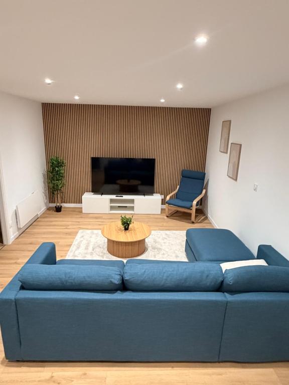 een woonkamer met een blauwe bank en een tafel bij L élégance centre historique Dole 70 m2 in Dole