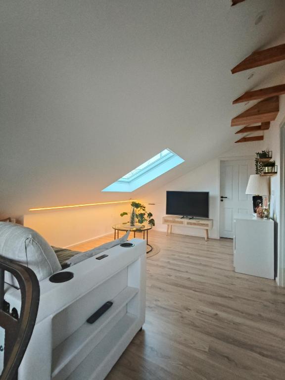 een woonkamer met een bed en een televisie bij Stilvolles Apartment im Loft-Style & Klimaanlage in Plaidt