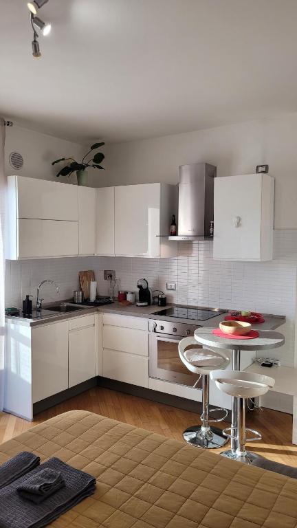 a kitchen with white cabinets and a table in it at MINI House - 3 min dal GRA By followgreenhouserome in Rome