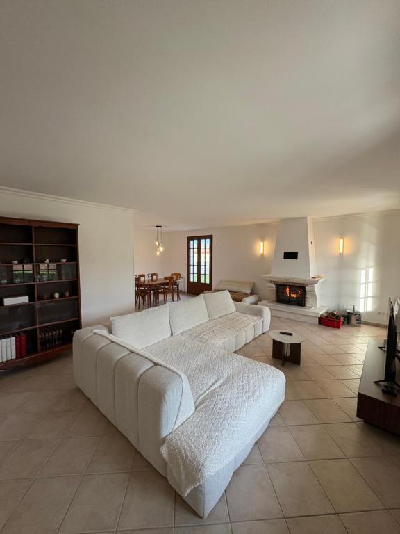 een woonkamer met een witte bank en een open haard bij La Maison Douce in Châtillon-sur-Seine