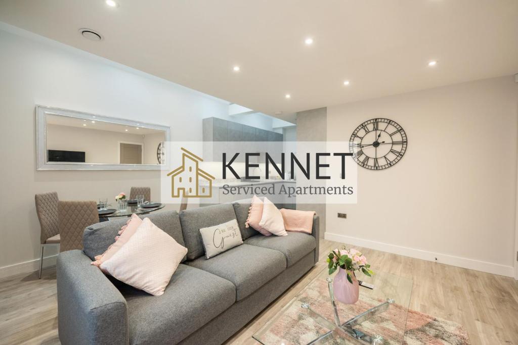 een woonkamer met een grijze bank voor een bord bij Chester House in Reading